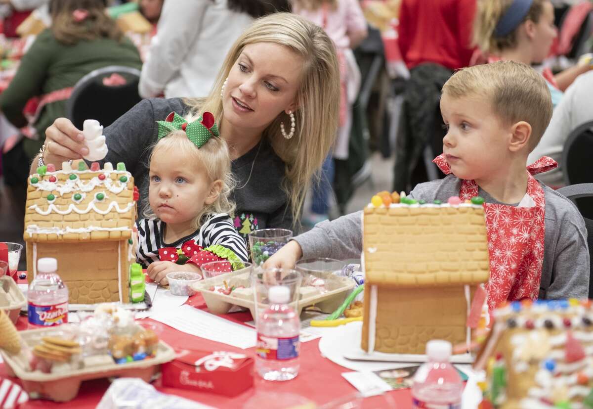 Tatum Dorow, with her daughter Lilly and son Gunner work on decorating their gingerbread house 12/03/19 at the annual Gingerbread Haven benefiting Midland Fair Havens. Tim Fischer/Reporter-Telegram