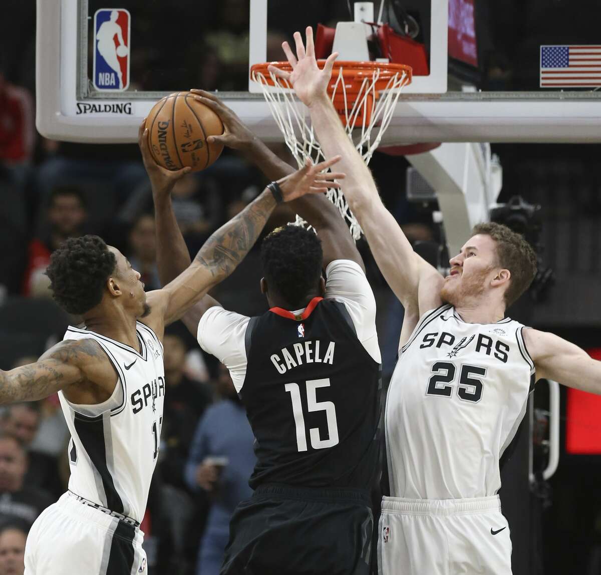 Spurs' DeMar DeRozan (10) and Jakob Poeltl (25) defend against Houston Rockets' Clint Capela (15) during their game at the AT&T Center on Tuesday, Dec. 3, 2019.