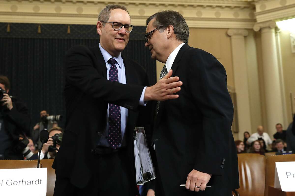 Constitutional law experts University of North Carolina Law School professor Michael Gerhardt, left, and George Washington University Law School professor Jonathan Turley, talks as they arrive to testify during a hearing before the House Judiciary Committee on the constitutional grounds for the impeachment of President Donald Trump, Wednesday, Dec. 4, 2019, on Capitol Hill in Washington. (AP Photo/Jacquelyn Martin)
