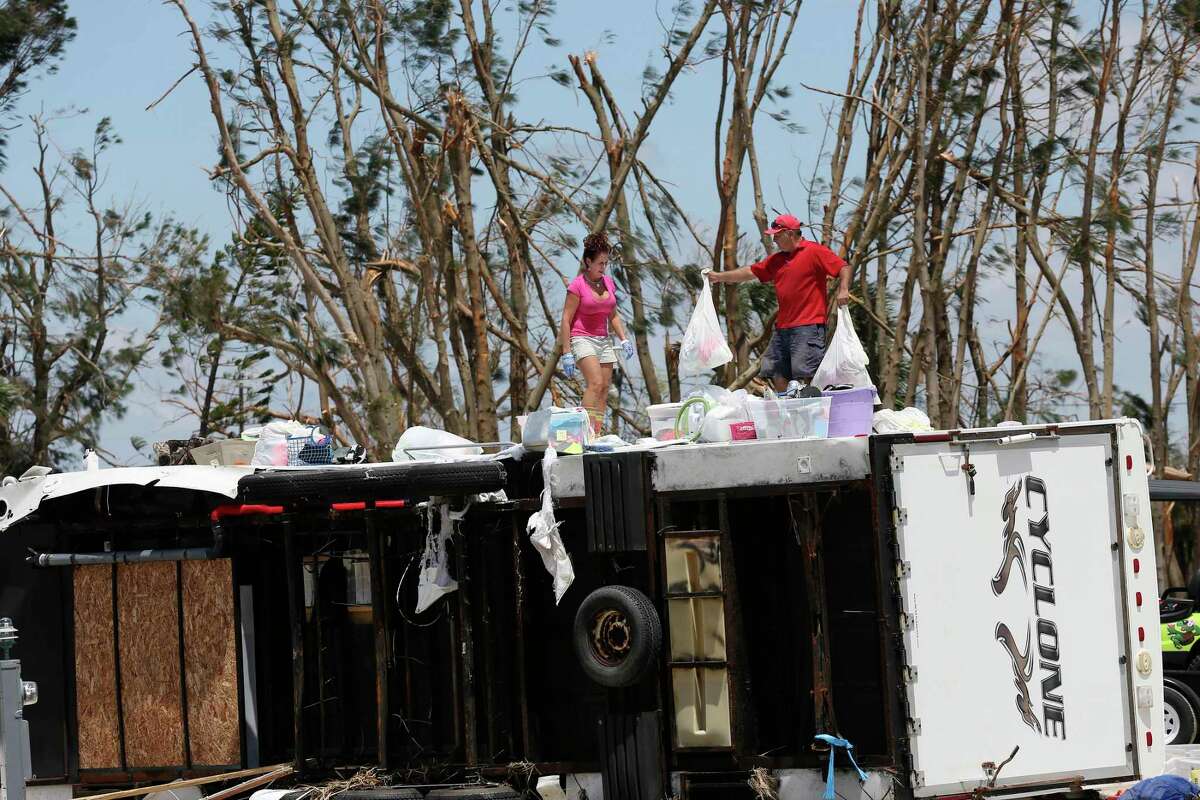 Glen Gonzales, 47, helps Brenda Travieso, 53, both from San Antonio, remove personal belongings from a travel trailer in the Tropic Island Resort in Port Aransas, Texas. The trailer and many others in the area were damaged by the surge and wind from Hurricane Harvey last Friday night.
