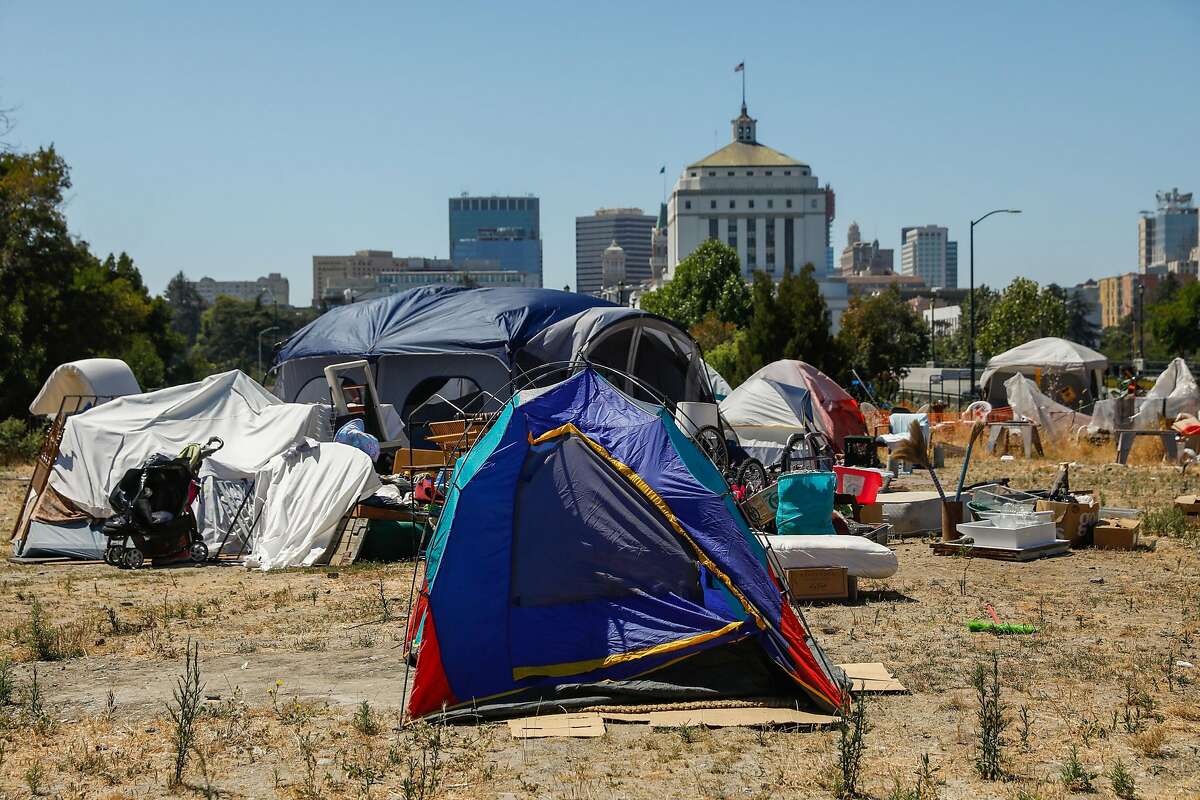 Tents are seen at an encampment on East 12th Street in Oakland, California, on Wednesday, July 24, 2019. Ollie and his partner Debbie are currently homeless. They went through Oakland's Tuff Shed program where they resided before getting permanent housing in Stockton. After spending a month in an apartment in Stockton the couple moved back to an encampment in Oakland because they claimed the apartment was infested with rats and cockroaches.