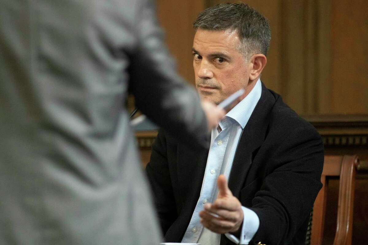 Fotis Dulos, right, is handed a financial document by his attorney William Murray during testimony in a civil case in Hartford Superior Court during his testimony in a civil case Wednesday, Dec. 4, 2019, in Hartford, Conn., brought by Gloria Farber, the mother of Jennifer Farber Dulos, his estranged wife who disappeared in May of this year. Farber claims Dulos owes around $3-million in unpaid loans to the estate of her late husband Hilliard Farber.