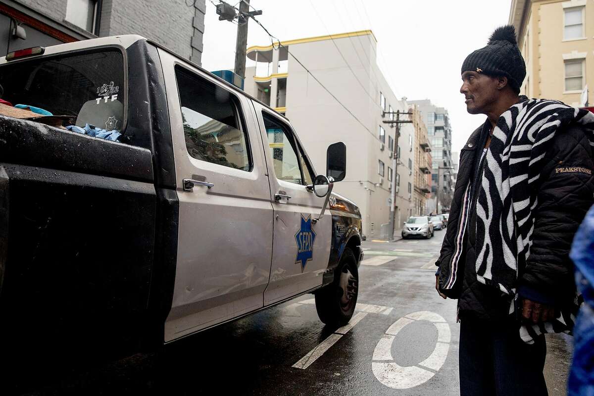 Rico (no last name given) watches as a SFPD truck drives down Willow Street with a bed full of homeless residents' belongings during a sweep of homeless tents and encampments by the Department of Public Works and San Francisco Police along Willow Street in San Francisco, Calif. Wednesday, Dec. 4, 2019.