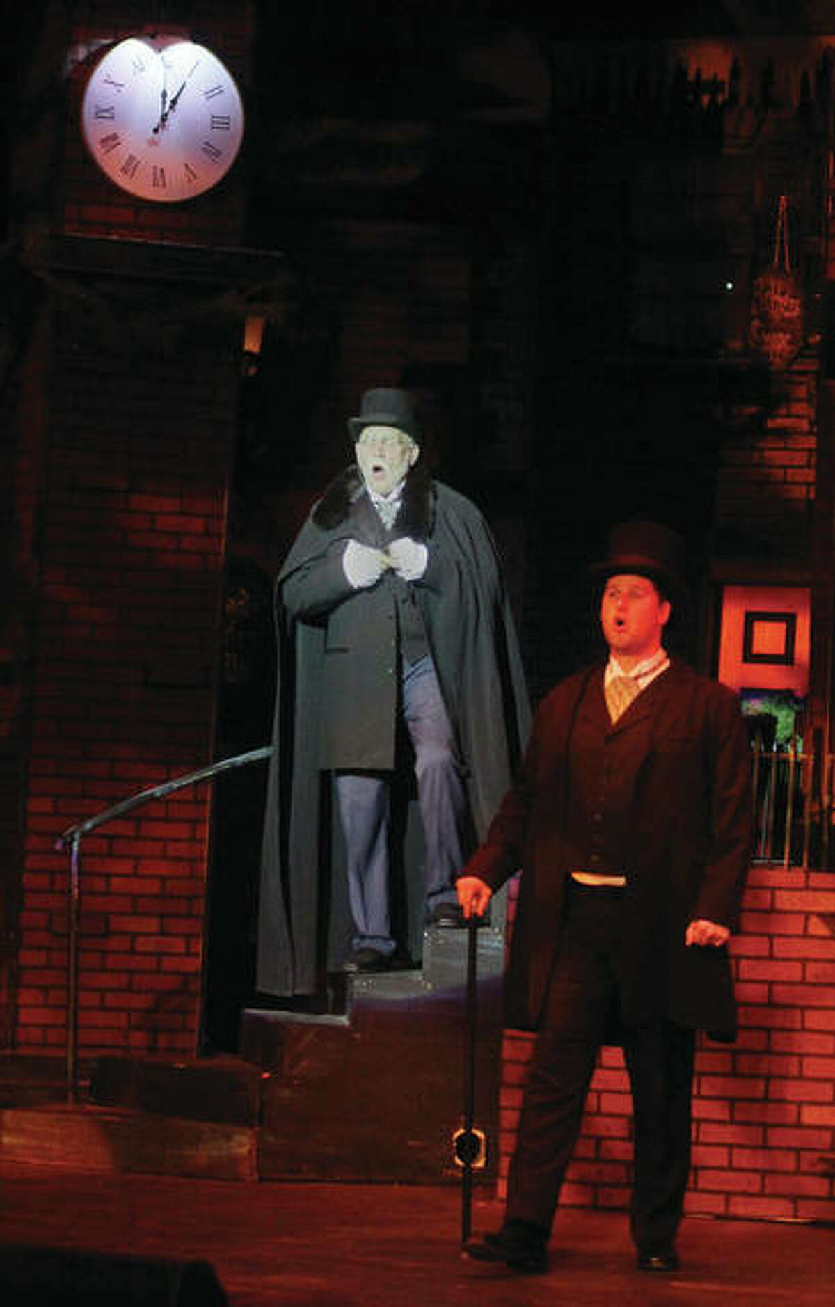 The Elder Ebenezer Scrooge, played by Don Stratton, sings with a version of his younger self, played by Nicolas Smith, while visiting Christmas scenes with the Ghost of Christmas Past in the Granite City High School production of “A Christmas Carol.” This is the 13th year of the production, which includes a cast and crew of more than 100 students and community members. The elaborate set includes a revolving stage, and several performers flying through the air. Public performances are Thursday through Saturday at 7 p.m. and 2 p.m. Sunday.