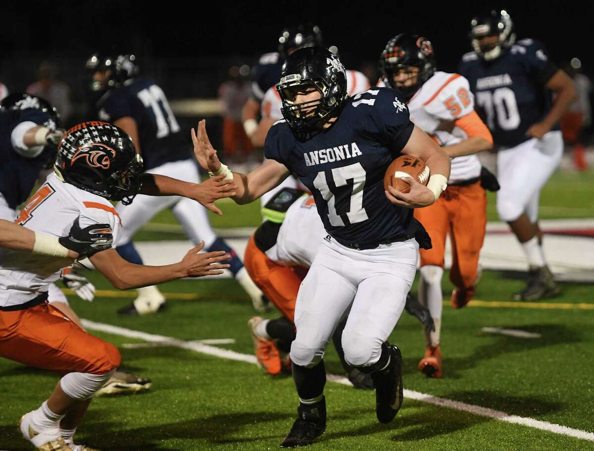 Ansonia runner Tyler Cafaro looks to stiff arm a Plainfield defender as he rushes the ball upfield in the first half of the Chargers' Class S football quartfinal in Derby, Conn. on Wednesday, December 4, 2019.