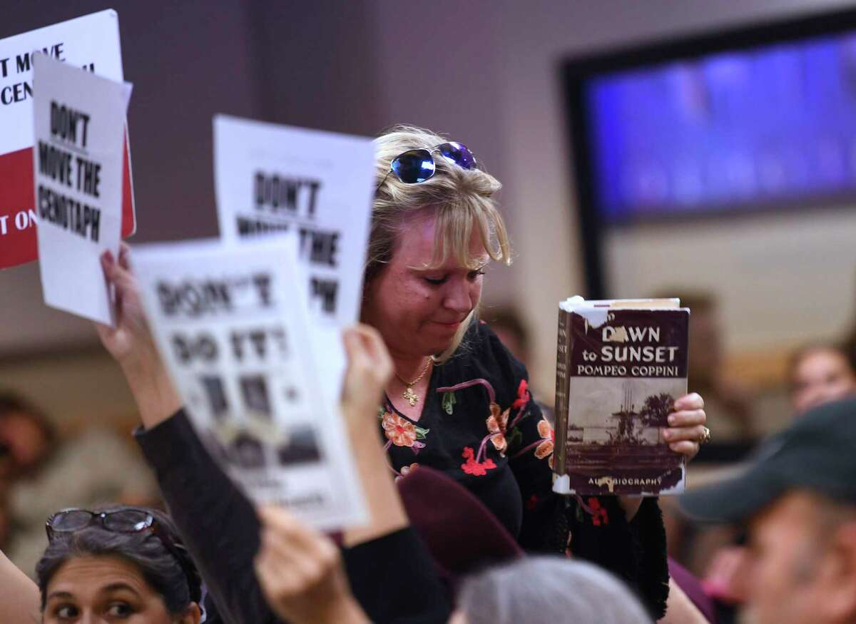 Cindy Gaskill holds up a book about Pompeo Coppini, the Italian artist responsible for the Cenotaph on the Alamo grounds, during the presentation on the first phase of the Alamo project at the city's Historic and Design Review Commission at the Development Service Building on Wednesday, Dec. 4, 2019. Gaskill spoke at the meeting, expressing her concern that moving the Cenotaph would go against the vision of the artist.