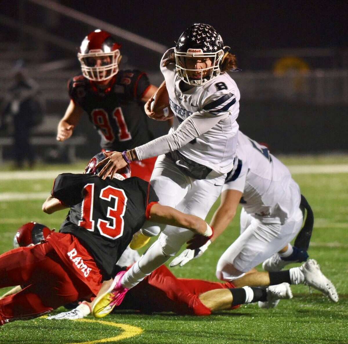 Wethersfield QB Matt Silver (8) runs with the ball while New Canaan’s Walker Swindell (13) goes for a tackle during the Class L football quarterfinals at Dunning Field on Wednesday, Dec. 4, 2019.