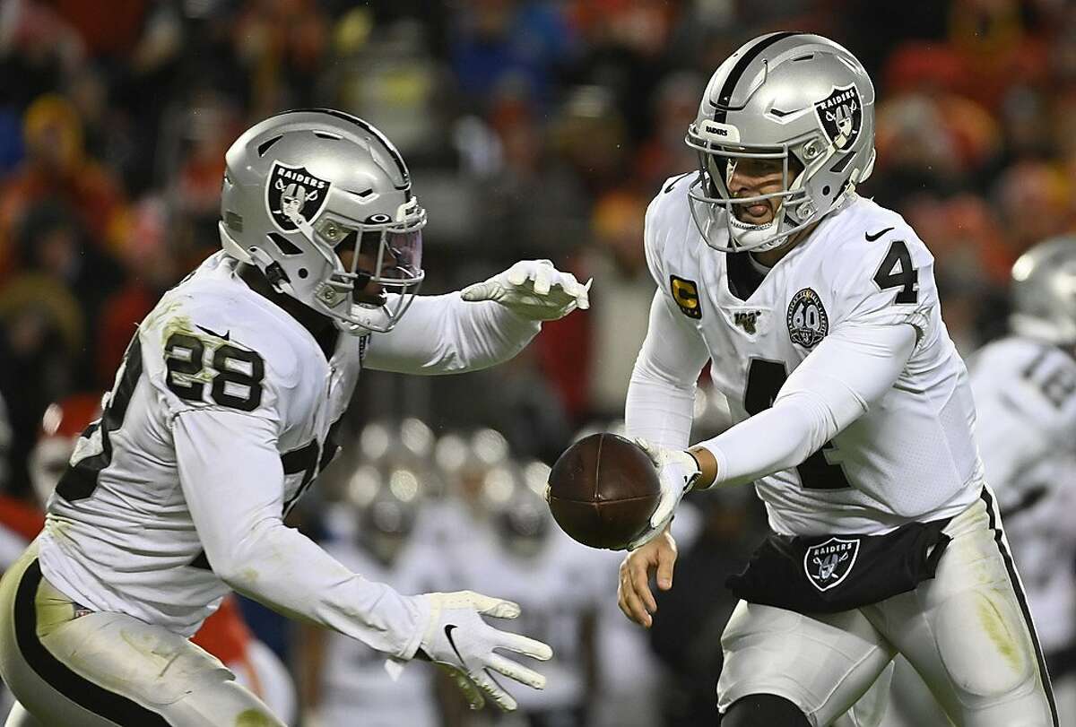 Oakland Raiders quarterback Derek Carr (4) hands off to Oakland Raiders running back Josh Jacobs (28) during the second half of an NFL football game against the Kansas City Chiefs in Kansas City, Mo., Sunday, Dec. 1, 2019. (AP Photo/Reed Hoffmann)