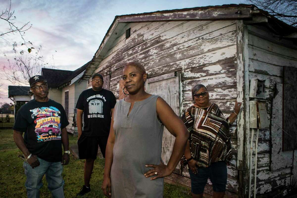 Rene Long, left, Richard Hudson, Sandra Edwards and Mary Hutchins stand in front of an abandoned home in their Fifth Ward neighborhood on Thursday, Dec. 5, 2019, in Houston. A cancer cluster was identified in the the historically black north Houston neighborhoods of the Fifth Ward and Kashmere Gardens, near a site of legacy contamination from rail yard operations. Creosote was used for decades to treat wooden railroad ties in the yard. Though wood treatment has ceased for many years, the creosote sunk deep into the ground, creating a plume that has moved beneath an estimated 110 homes. The cancers identified in the cluster are associated with the contaminants found in creosote.