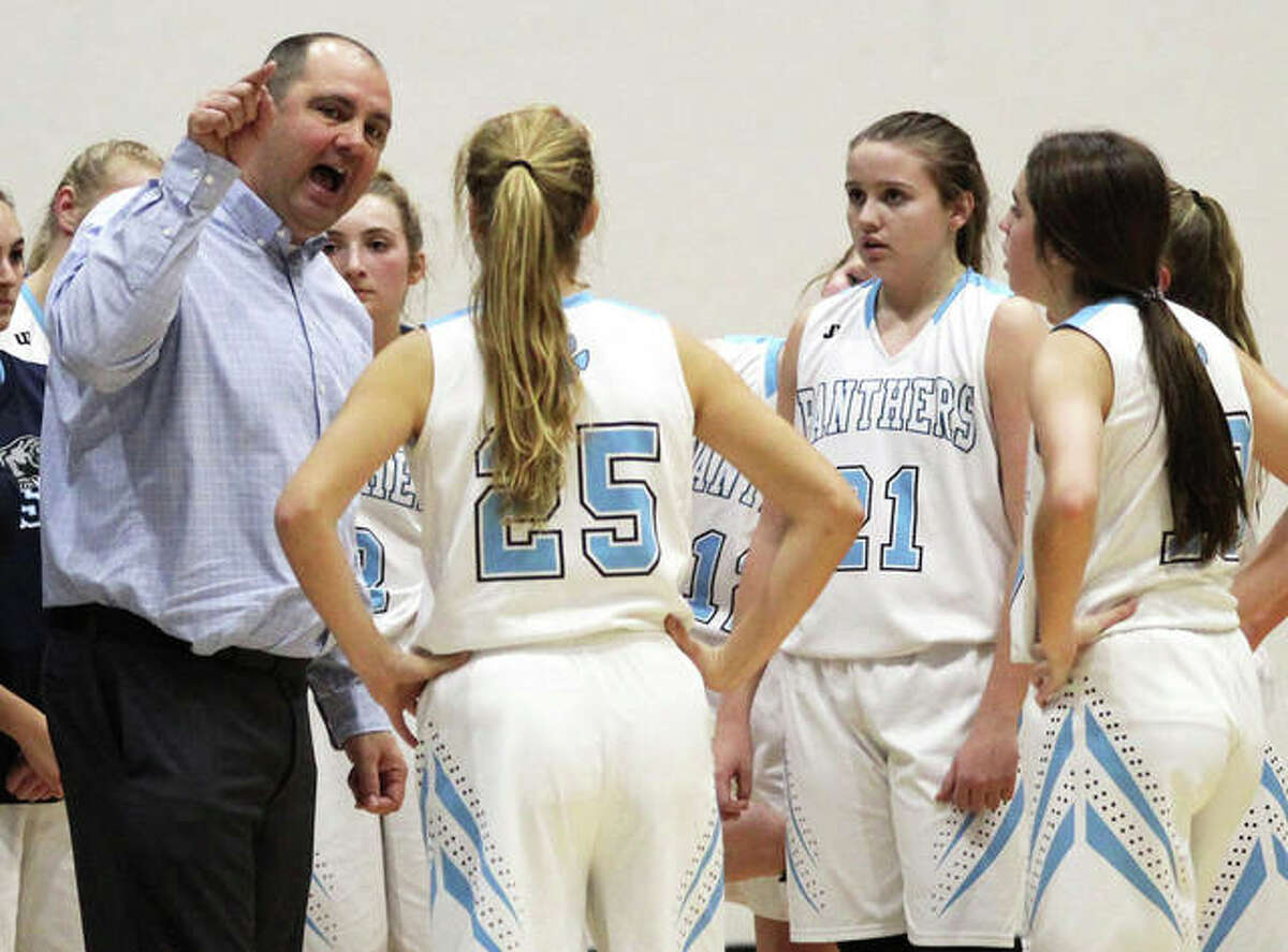 Jersey coach Kevin Strebel (left) makes a point to his team during a timeout in a game last season at Havens Gym in Jerseyville. The Panthers were back home Thursday and opened MVC play with a rout of Mascoutah.