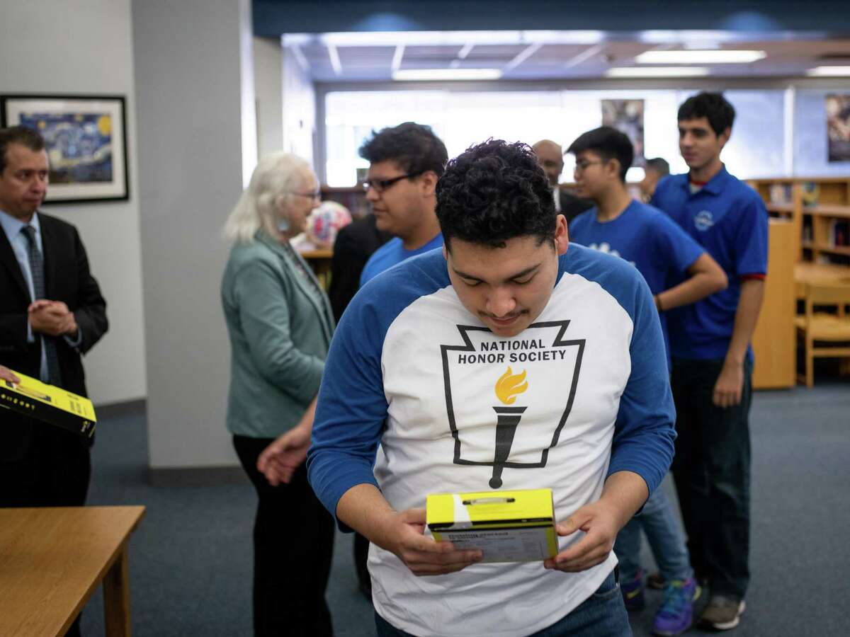 Senior Dominico Rocco Aguero looks at the free smart phone he received through the 1Million Project Foundation, which provides free internet connectivity devices to school students in need, at Sidney Lanier High School on Friday. SAISD partnered with the foundation to supply 5,200 high school students throughout the district with free wireless connectivity via smart phones or hotspot devices for their homes.
