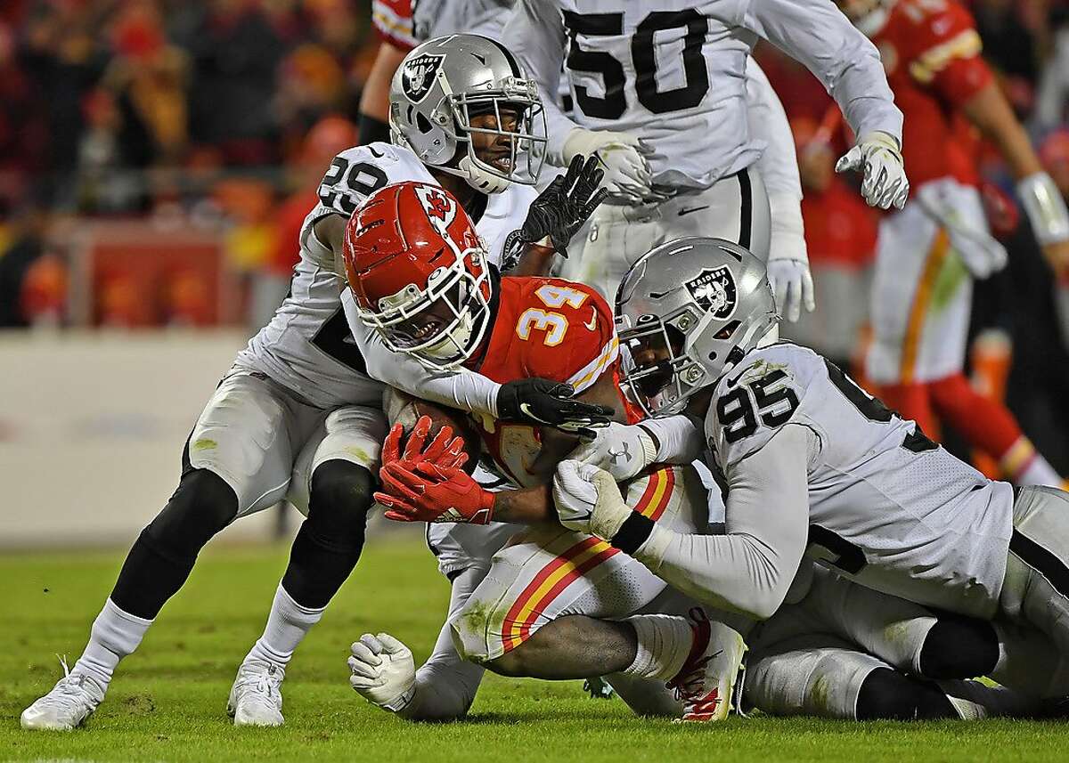 KANSAS CITY, MO - DECEMBER 01: Free safety Lamarcus Joyner #29 and defensive end Dion Jordan #95 of the Oakland Raiders tackle running back Darwin Thompson #34 of the Kansas City Chiefs during the second half at Arrowhead Stadium on December 1, 2019 in Kansas City, Missouri. (Photo by Peter Aiken/Getty Images)