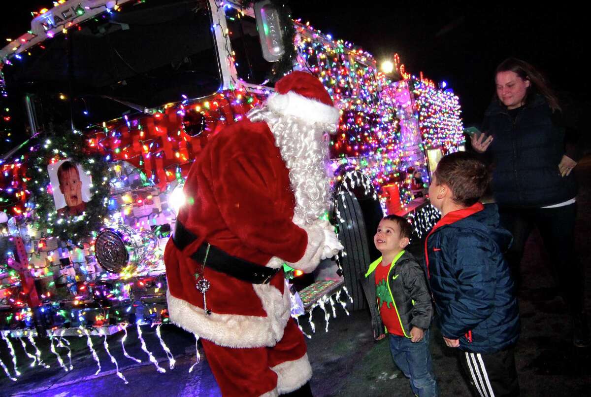 Before departing in his holiday decorated fire truck, Santa stops to chat with Ethan Picart, 2, in center, and his big brother Tyler, 6, at the annual holiday tree lighting event at Town Hall Green in Trumbull, Conn., on Friday Dec. 6, 2019.