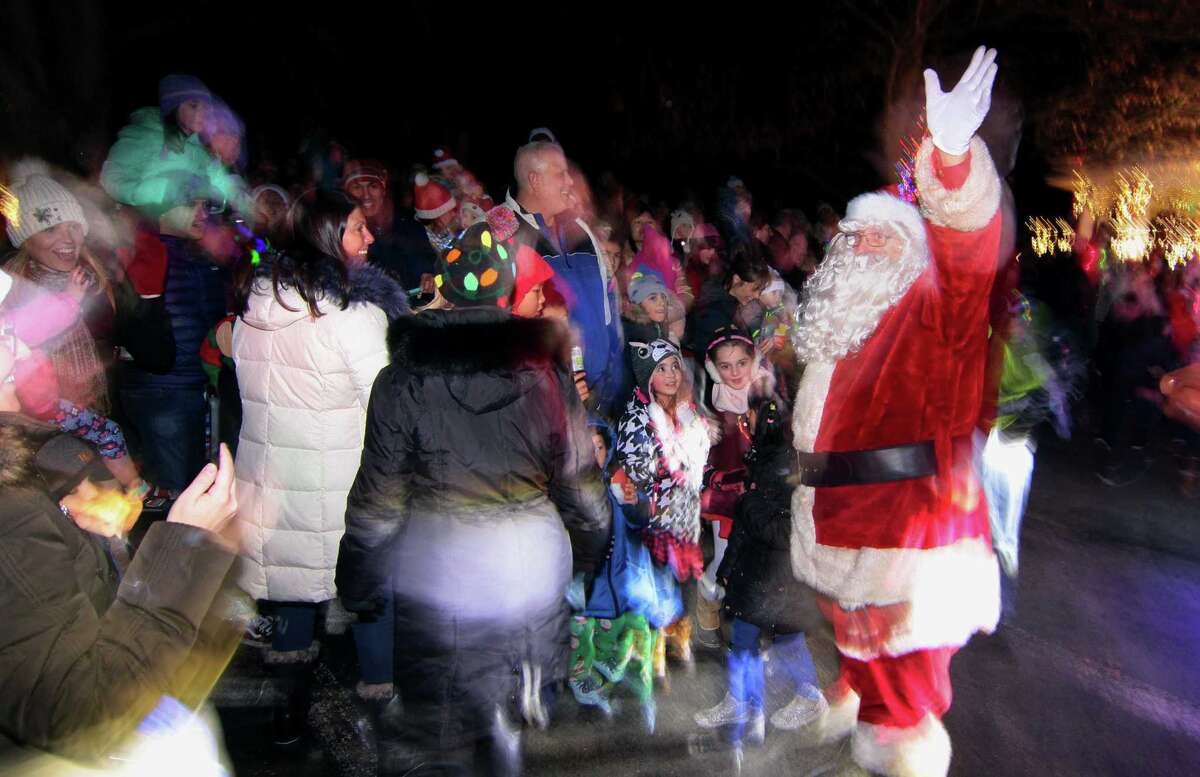 Santa waves to the children after arriving for the annual holiday tree lighting event at Town Hall Green in Trumbull, Conn., on Friday Dec. 6, 2019.