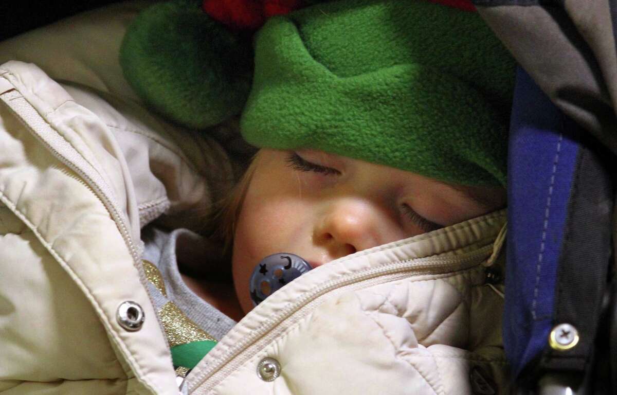 Colleen Walsh, 2 of Trumbull, fell asleep before getting a chance to tell Santa what she wants for Christmas during the annual holiday tree lighting event at Town Hall Green in Trumbull, Conn., on Friday Dec. 6, 2019.