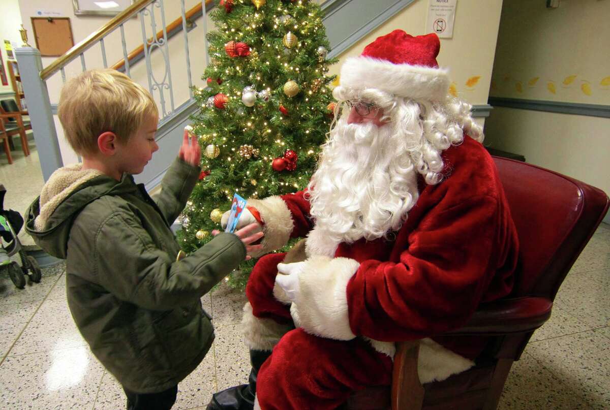 Santa visits with the children during the annual holiday tree lighting event at Town Hall Green in Trumbull, Conn., on Friday Dec. 6, 2019.