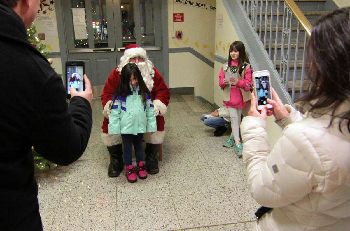 Santa visits with the children during the annual holiday tree lighting event at Town Hall Green in Trumbull, Conn., on Friday Dec. 6, 2019.