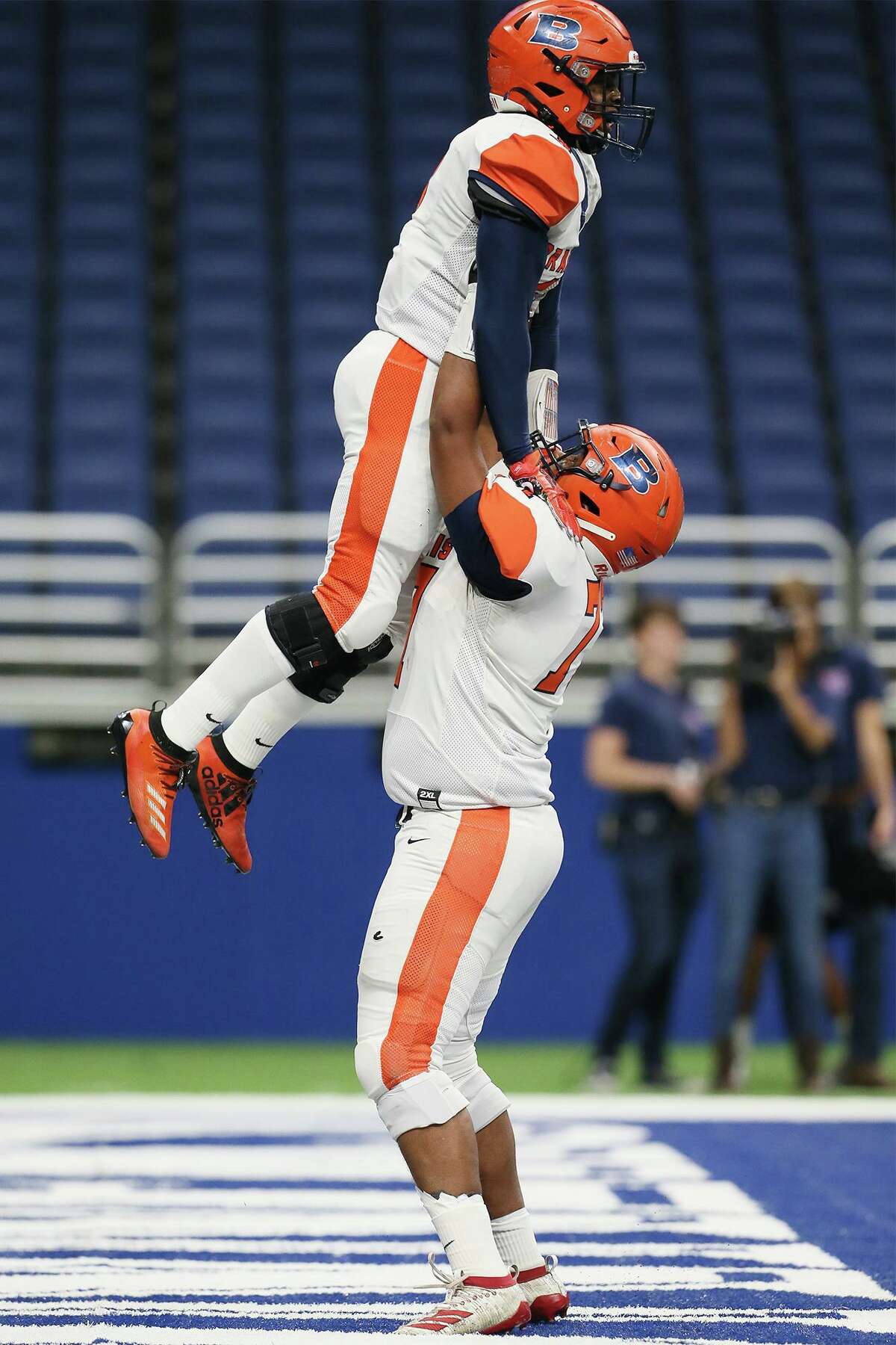Brandeis' Matt Thomas hoists Corion Holmes into the air after Holmes' 18-yard touchdown reception during the first half of their Class 6A Division II State Quarterfinal high school football game with Austin Westlake at the Alamodome on Friday, Dec. 6, 2019.
