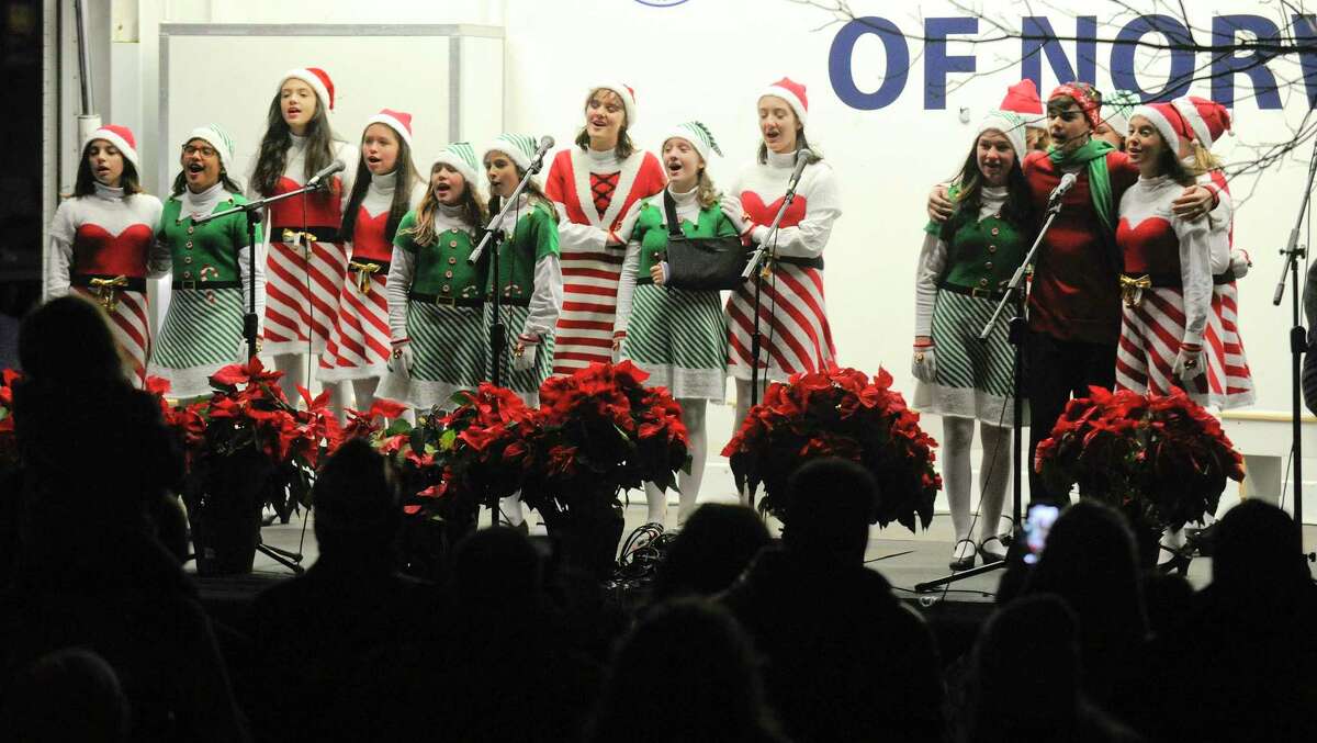 Above, members of the Crystal Theatre Performers sing Christmas Carols during the annual Holiday Tree Lighting Celebration on the front lawn of City Hall in Norwalk on Friday. Right,