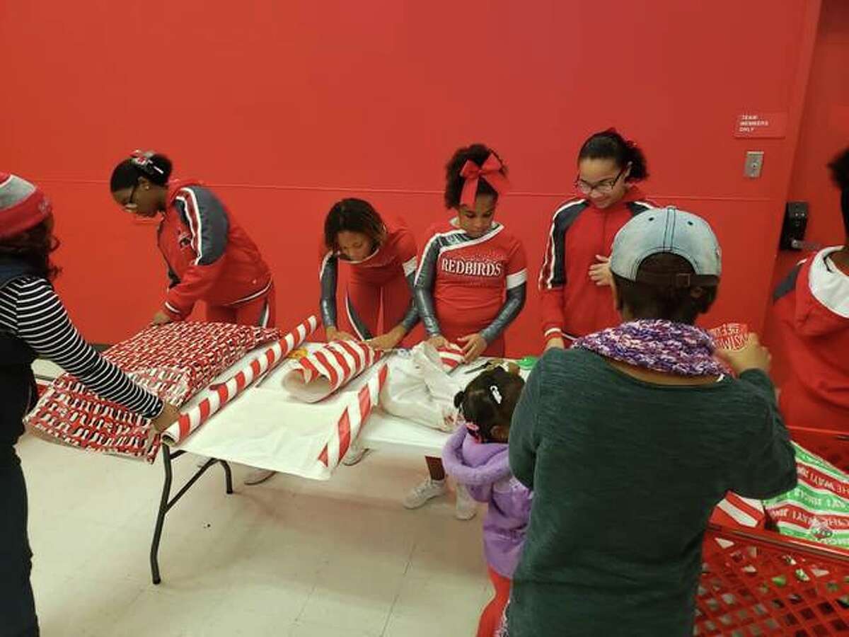 Alton School District students wrap gifts Saturday during the annual Shop With A Cop, organized by the Police Benevolent and Protective Association Alton Unit 14, at Target. The union organization supports officers of the Alton Police Department.