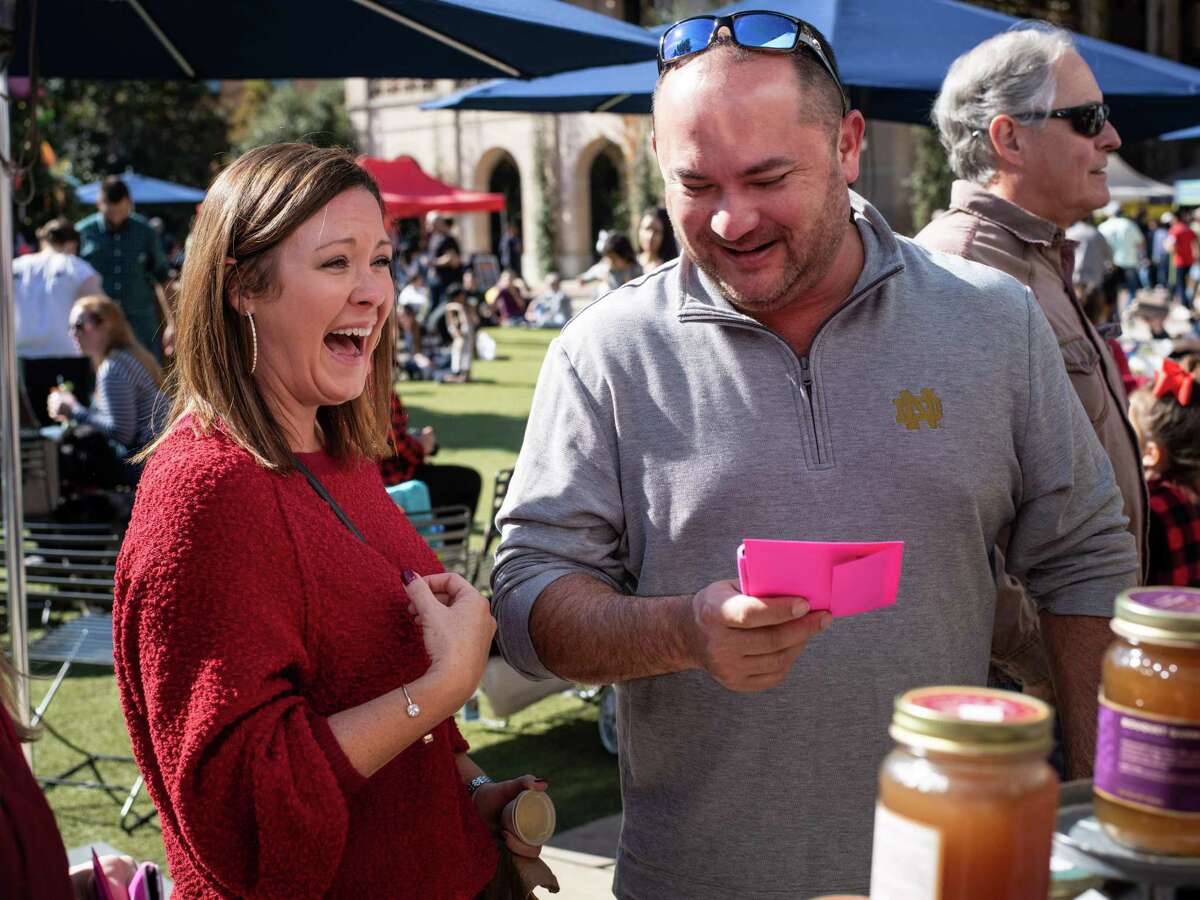 Amber and Scott Phillips react after receiving an envelope full of free cash from The Awesome Foundation in San Antonio, Texas on Saturday, December 7, 2019. The Awesome Foundation is an international organization with local chapters that award $1000 grants each month through an application process that promotes, ?’Awesomeness?“ in the community. This is the third December where the San Antonio chapter has decided to pass out envelopes containing 5, 10, and 20 dollar bills to unsuspecting people around San Antonio.