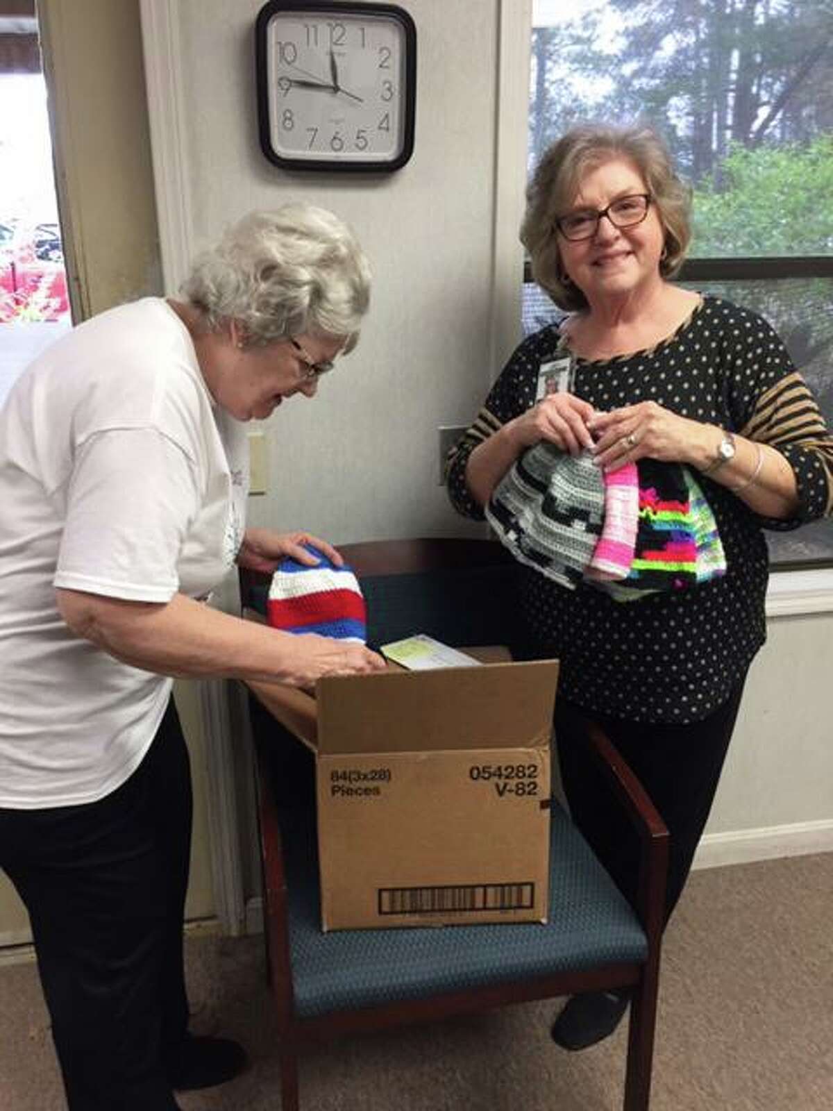 Volunteers at Bridegwood Farms pour through a box of colorful hand made hats donated to Bridgewood for Christmas gifts for the residents. The hats were lovingly made by Gladys Manning of Austin, part of The RC of Conroe's extended Family of Rotary.