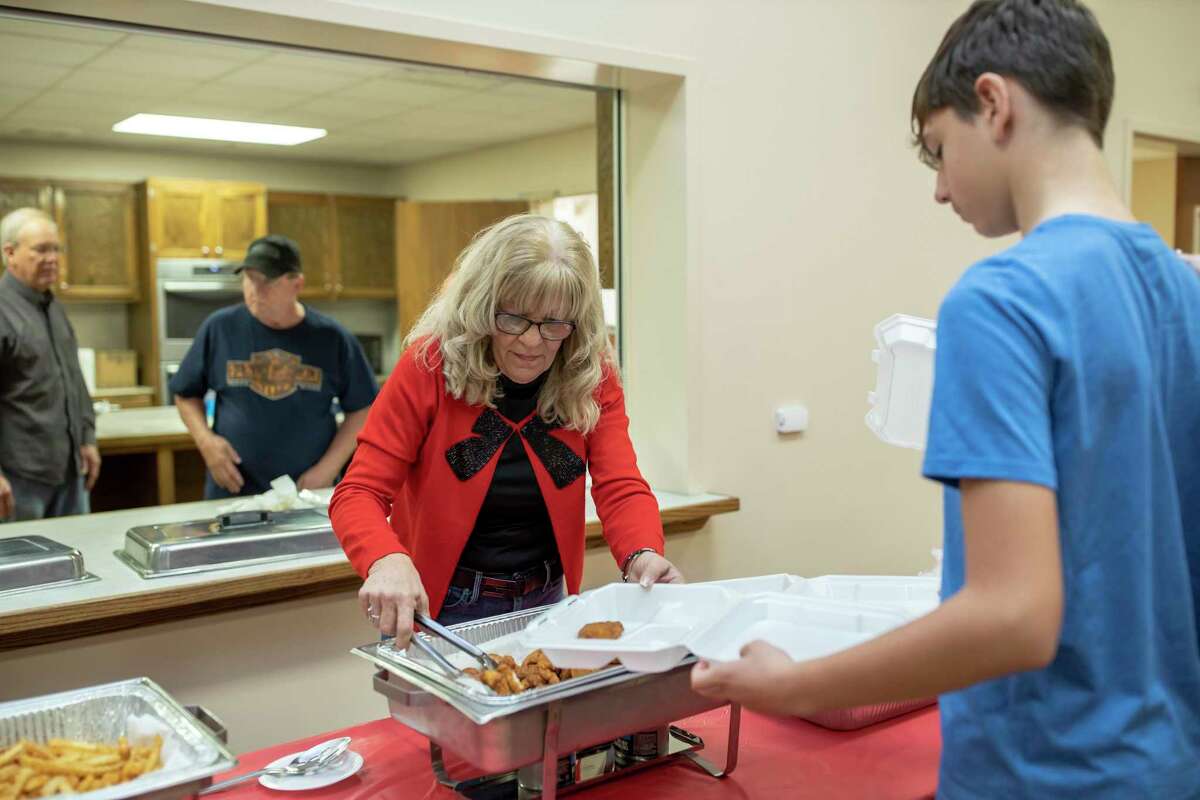 Cheryl Anderson serves fried catfish, hushpuppies, coleslaw and fries during the inaugural Family Promise Christmas Celebration Saturday, Dec. 7, 2019. Attendees paid $10 for a complete catfish dinner in support of the families that are assisted by Family Promise.