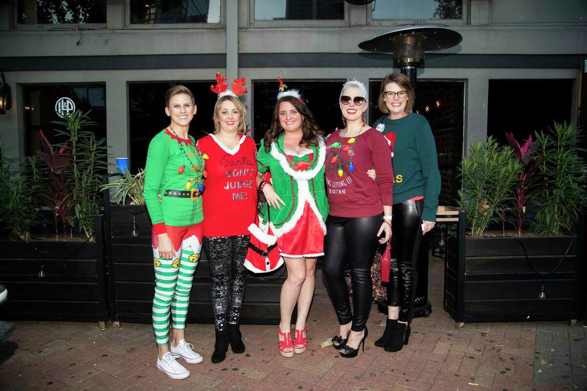 Guests participate in the Ugly Sweater Pub Crawl at the Henke & Pillot pub on Saturday, Dec. 7, 2019, in Houston.