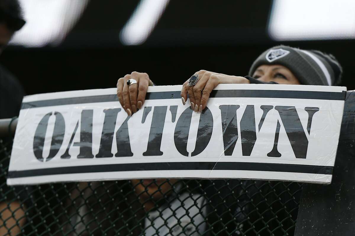 An Oakland Raiders fan holds up an Oaktown sign during the second half of an NFL football game between the Raiders and the Tennessee Titans in Oakland, Calif., Sunday, Dec. 8, 2019. (AP Photo/D. Ross Cameron)