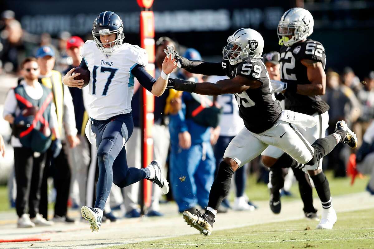 Oakland Raiders' Tahir Whiotehead pushes Tennessee Titans' Ryan Tannehill out of bounds in 2nd quarter during NFL game at Oakland Coliseum in Oakland, Calif., on Sunday, December 8, 2019.