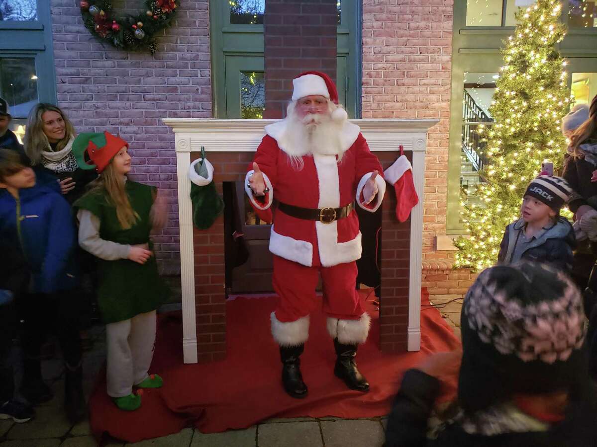 Santa Claus comes down the chimney at the Holiday Magic event.