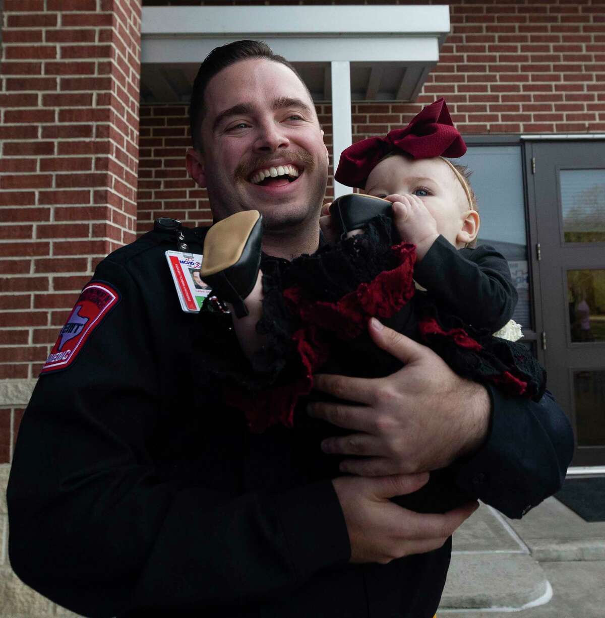 Montgomery County Hospital District paramedic Larson Johnson shares a laugh as he holds eight-month-old Khloe Mock during a visit to Montgomery Fire Station 51, Wednesday, Dec. 4, 2019, in Montgomery. Firefighters from Station 51 and MCHD paramedics reunited with Mock and her family after they helped her mother, Lindey, deliver Khloe in the back of her SUV while traveling on Texas-105 back on March 22.