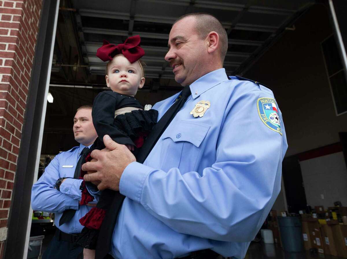 Montgomery firefighter Robert Sebastia, right, holds 8-month-old Khloe Mock on Wednesday.