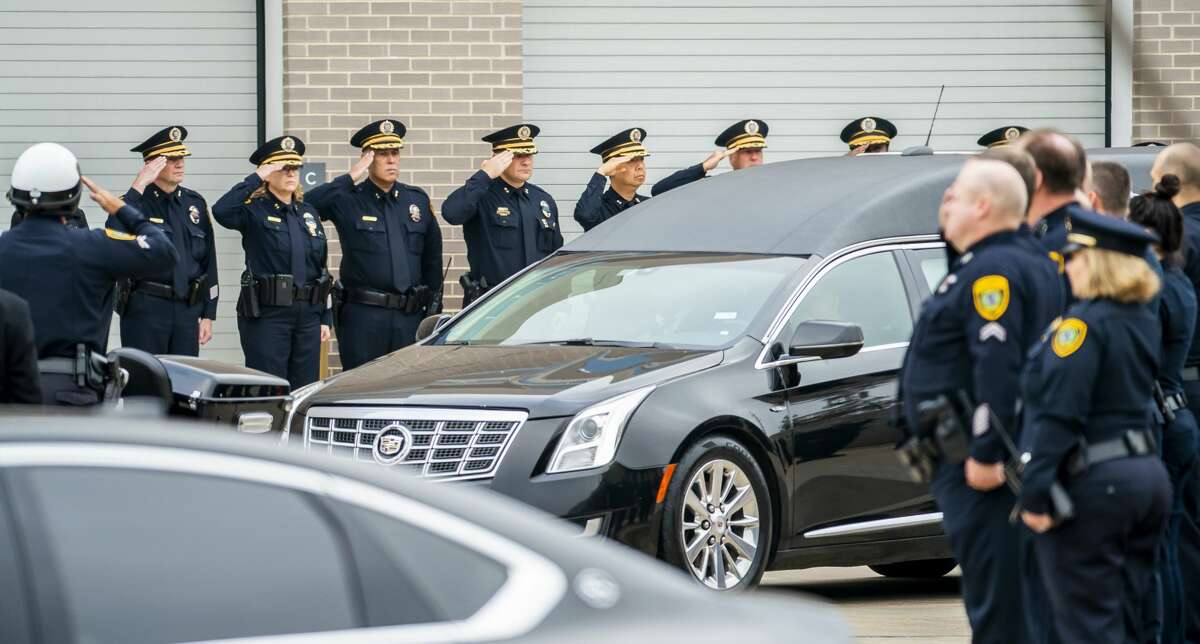 Commanders and officers from the Houston Police Department salute as the body of Sgt. Christopher Brewster is brought out of the Harris County Institute of Forensic Sciences building to be escorted to a funeral home in preparation for Wednesday's planned visitation and a funeral planned for Thursday, in Houston, Monday, Dec. 9, 2019.