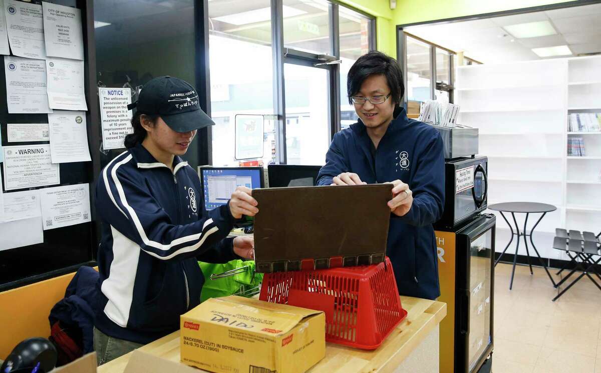 Daido staff Naota Noguchi, left, and store manager, Toyo Hagiwara, work at counter on Friday, Dec. 6, 2019, in Houston. Daido, the first major Japanese grocer in Houston that closed in September, recently reopened under new management. Hagiwara, with the help of investors, bought out the business from its New York owners in November.