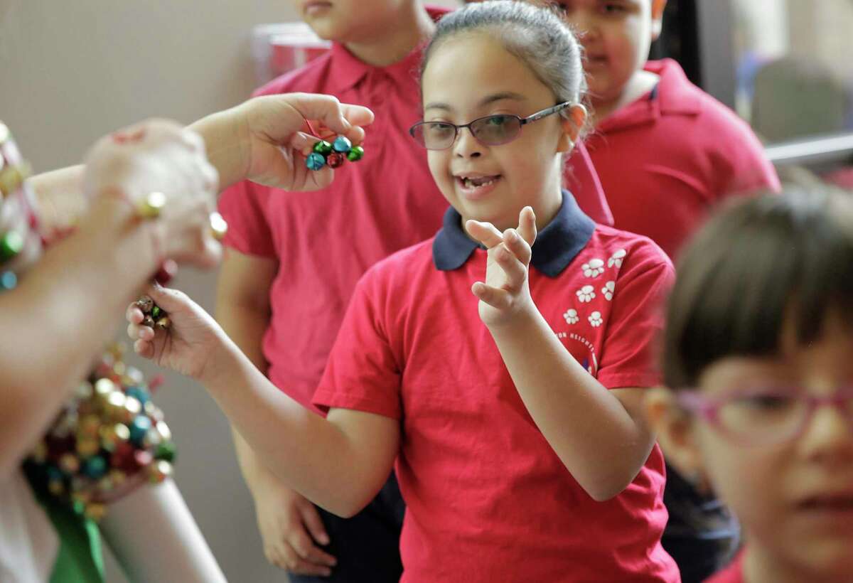 Linzey Leiva, 10, a Houston Heights Elementary student, is all smiles as she receives her bell bracelet for the “Touch, Smell and Hear” event at John P. McGovrn Museum of Health and Medical Science on Monday, Dec. 9, 2019 in Houston. More than 400 children participated in the event that included Christmas trees, music, Santa and Mrs. Clause and bubble machines.