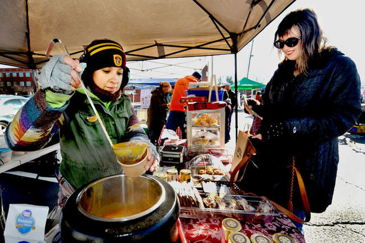 Queens Cuisine Tea Room employee Lupe Gomez, left, pours some pumpkin soup into a cup for Holly Hampton during this year’s Winter Market on Saturday in downtown Edwardsville.