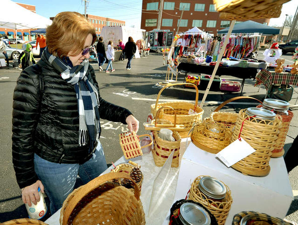 Kathy Singler of St. Charles looks over some baskets at the BeeWeave it or not table during this year’s Edwardsville Winter Market Saturday.