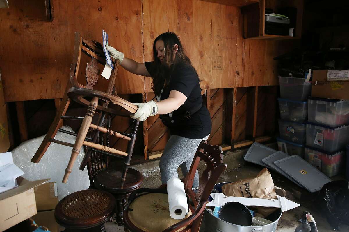 Rosamaria冈萨雷斯移动物品在她的车库丢弃物品被洪水损坏周六周一在她家里,12月9日2019年在旧金山,加州。