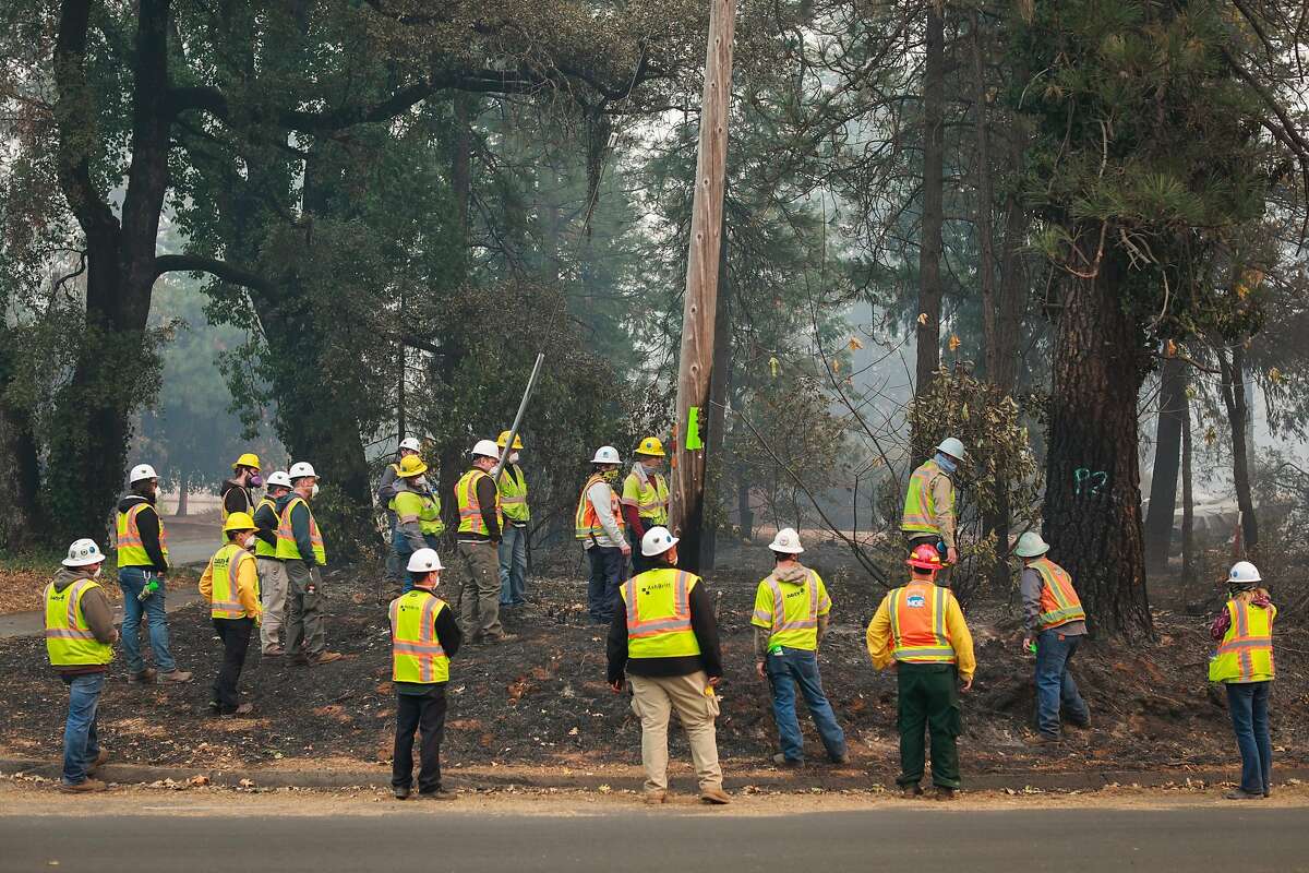 PG workers watch as trees are marked for cutting after the Camp Fire tore through the town of Paradise, California, on Wednesday, Nov. 14, 2018. PG is trying to finalize deals with parties affected by its bankruptcy and its role in starting California wildfires.