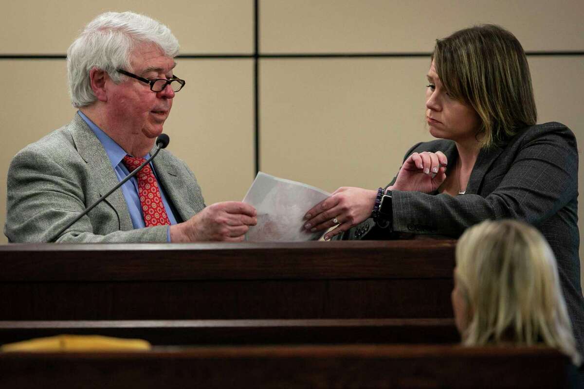 Dr. William Robert Anderson looks over evidence shown to him by prosecutor Alessandra Cranshaw as he testifies for the defense in the murder trial of Mark Howerton on Monday, Dec. 9, 2019.