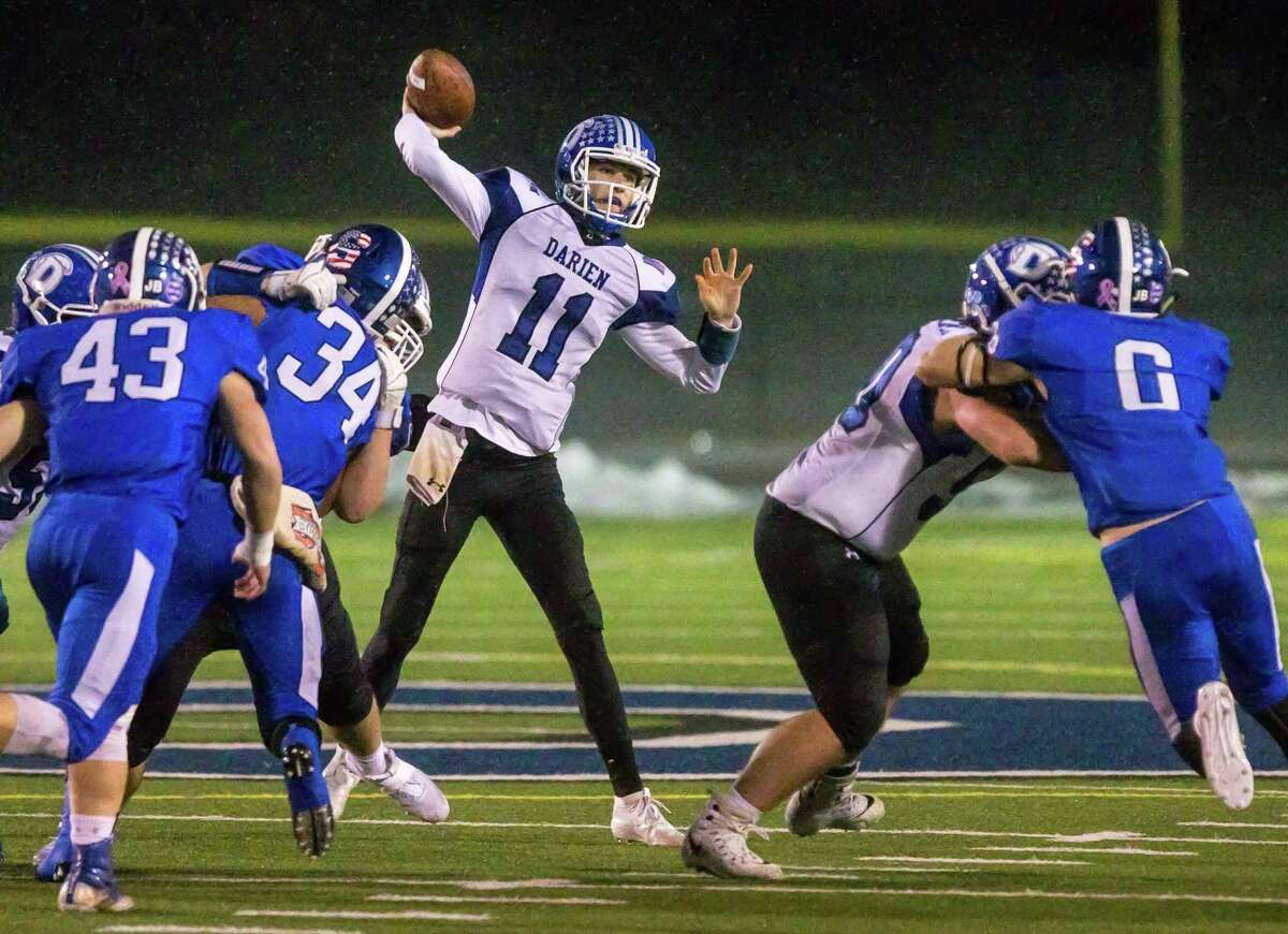Darien quarterback Peter Graham gets off a pass under pressure from Southington’s defense in their Class LL semifinal game Monday night in Southington. Darien won 21-12 to advance to the final.