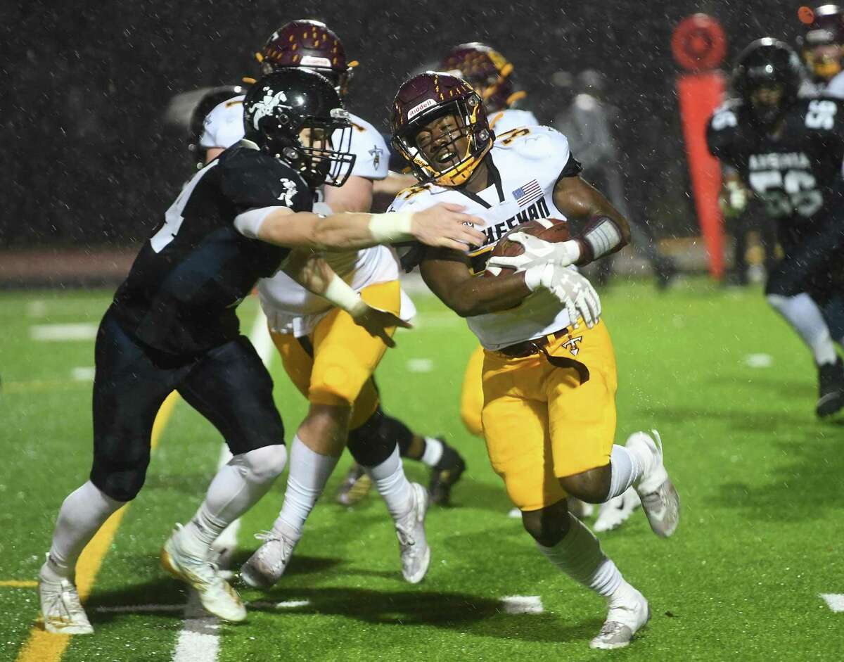 Ansonia's Noah Wagnblas looks to wrap up Sheehan runner Terrance Bogan in the first half of their Class S State Football semifinal at Ryan Field in Derby on Monday.