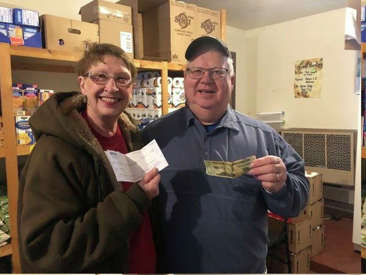 Nedra Ball and Humphrey VanderVlugt, who operate the Reed City Food Pantry, accept a check for $1,120 from Gerber Construction. Owners Bill and Jill Terryn matched $10 donations for every participant in the Trinity Lutheran Church and School Prepare For Pie 5k run and walk on Thanksgiving day. (Submitted photo)