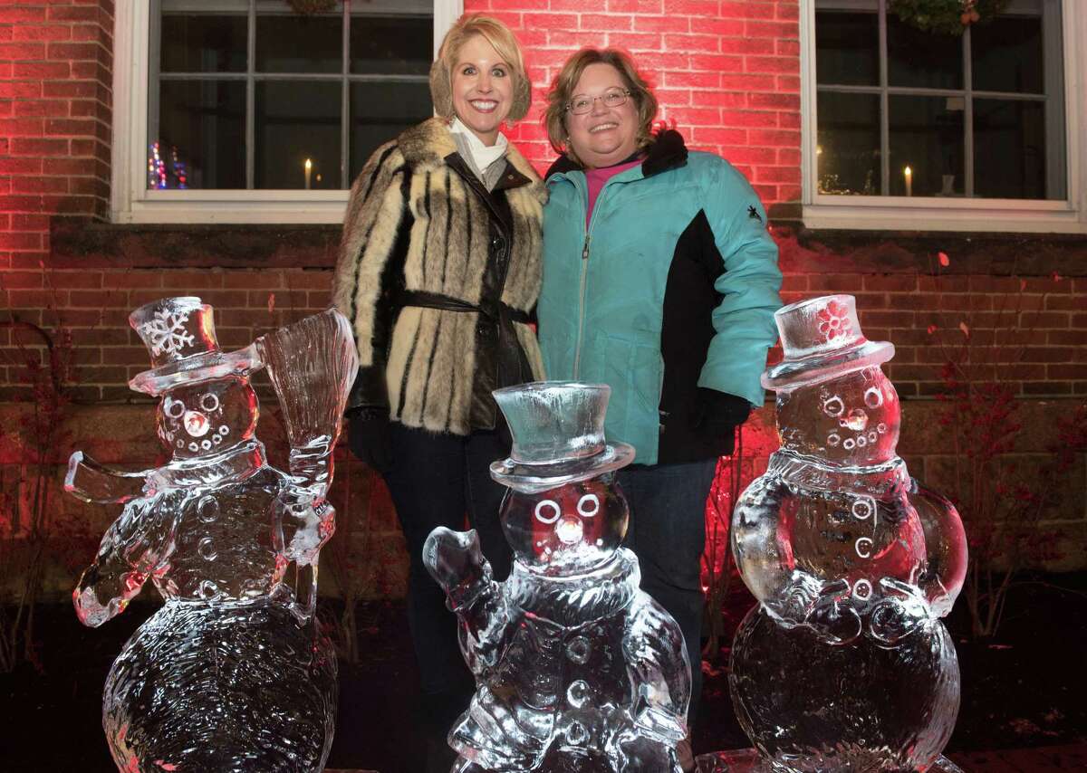 Denise Bertalovitz and Stacy Bisio pose in front of ice sculptures at the Ridgefield Holiday Stroll on Friday, Dec. 6, 2019 in Ridgefield.