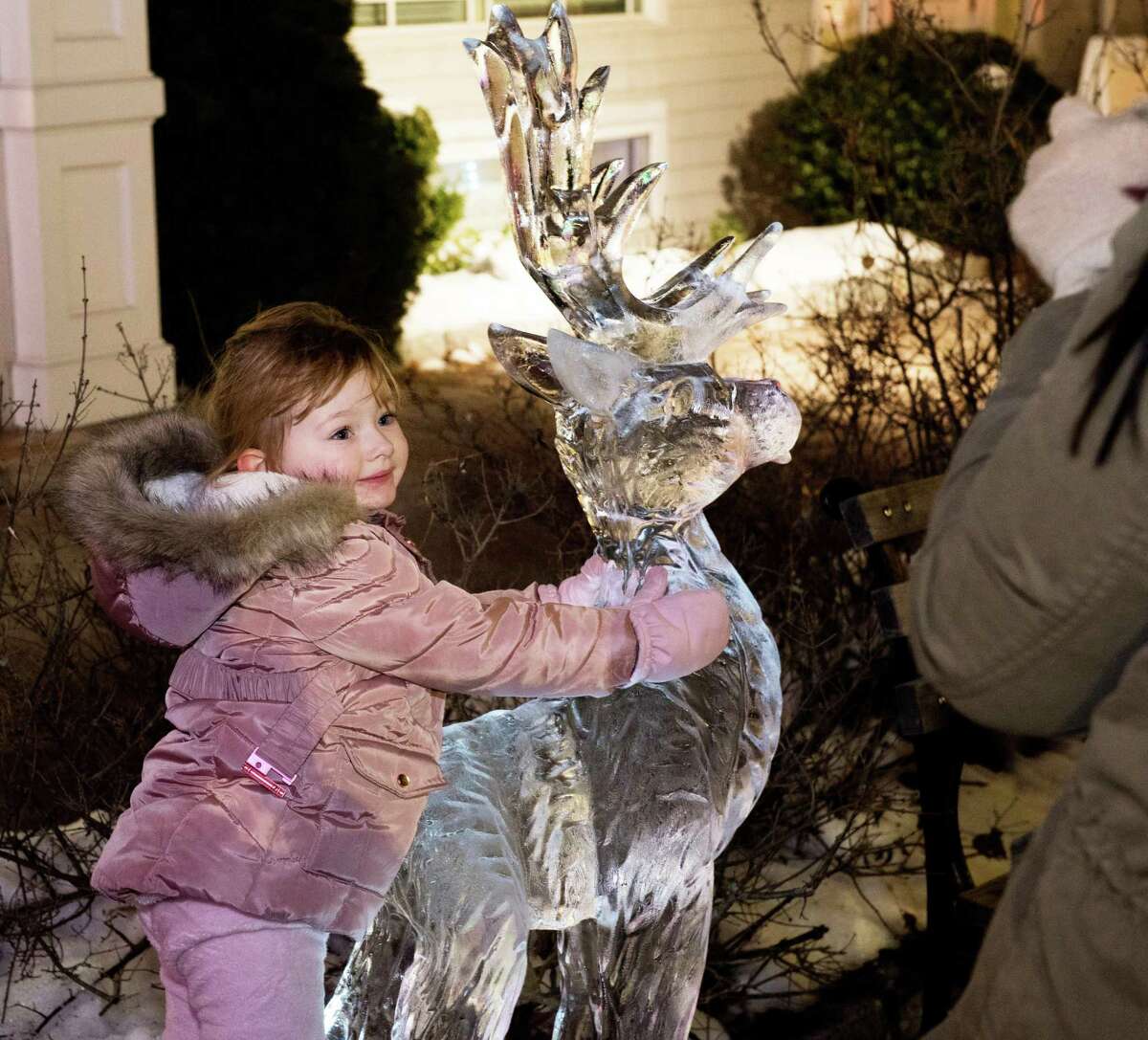 Remi Santucci, 3, hugs an ice reindeer at the Ridgefield Holiday Stroll on Friday, Dec. 6, 2019 in Ridgefield.