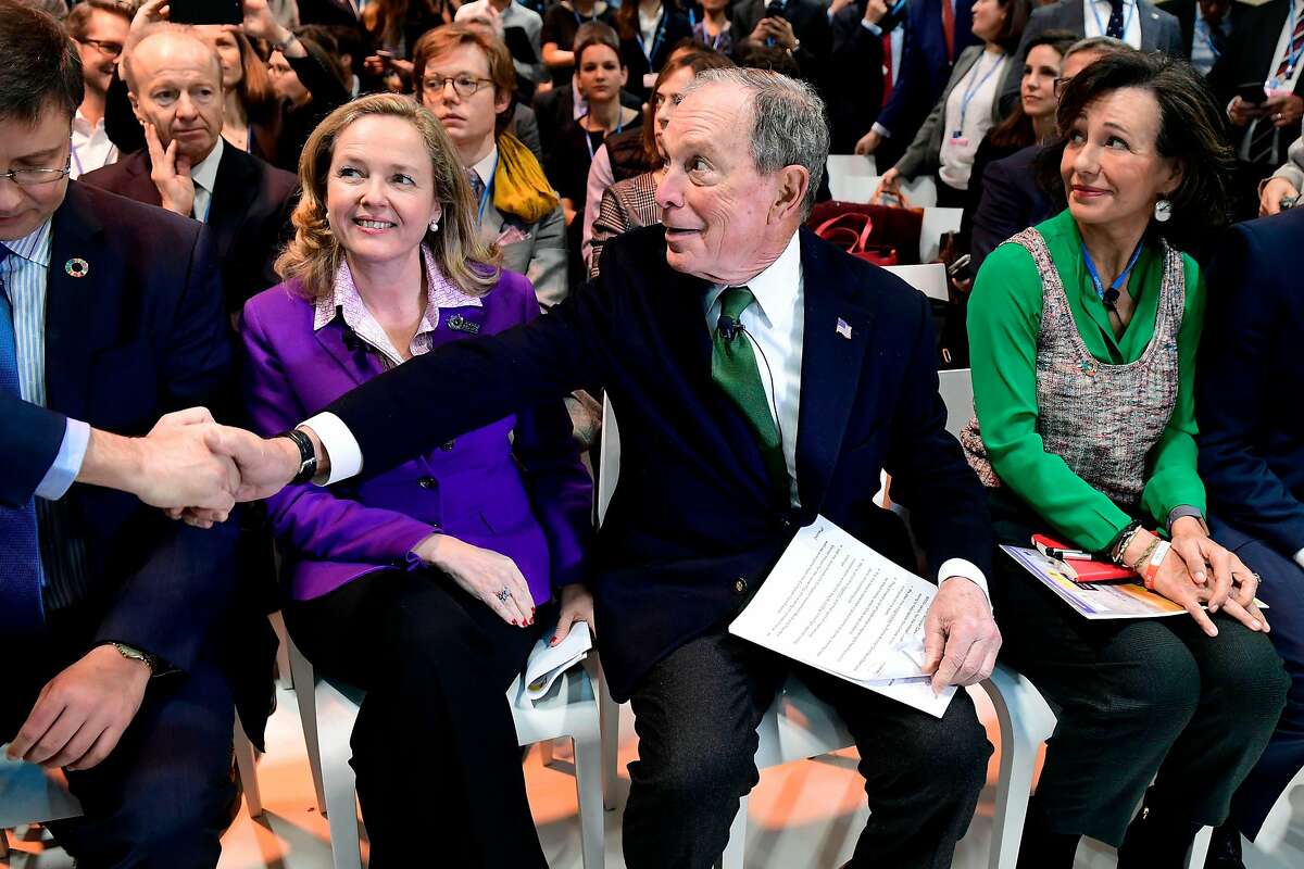 Democratic presidential hopeful Michael Bloomberg (C) sits between Spanish Santander Bank executive chairperson Ana Botin (R) and Spanish careteker minister for economic affairs Nadia Calvino as they attend an event within the UN Climate Change Conference COP25 at the 'IFEMA - Feria de Madrid' exhibition centre, in Madrid, on December 10, 2019. - UN climate negotiations in Madrid remained bogged down yesterday in the fine print of the Paris treaty rulebook, out-of-sync with a world demanding action to forestall the ravages of global warming. The 196-nation talks should kick into high-gear today with the arrival of ministers, but on the most crucial issue of all -- slashing the greenhouse gas emissions overheating the planet -- major emitters have made it clear they have nothing to say. (Photo by CRISTINA QUICLER / AFP) (Photo by CRISTINA QUICLER/AFP via Getty Images)