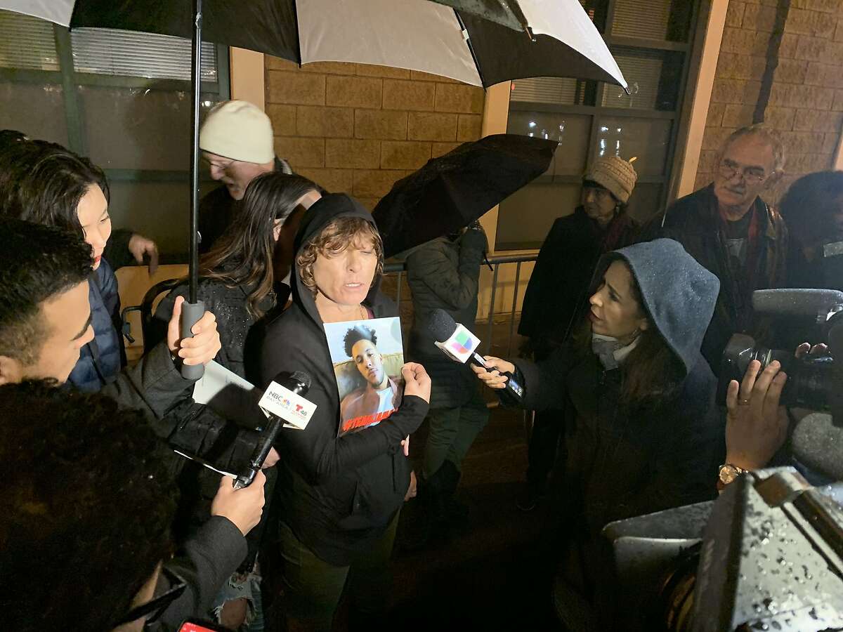 A woman, who identified herself only as the mother of the man critically shot by San Francisco police in the Missoin District, holds a photo of who she says is her son, Jamaica, 26, during a protest outside of the San Francisco Police Department's Mission Station on Tuesday, Dec. 10, 2019. She declined to provide the man's surname and did not identify herself to reporters.