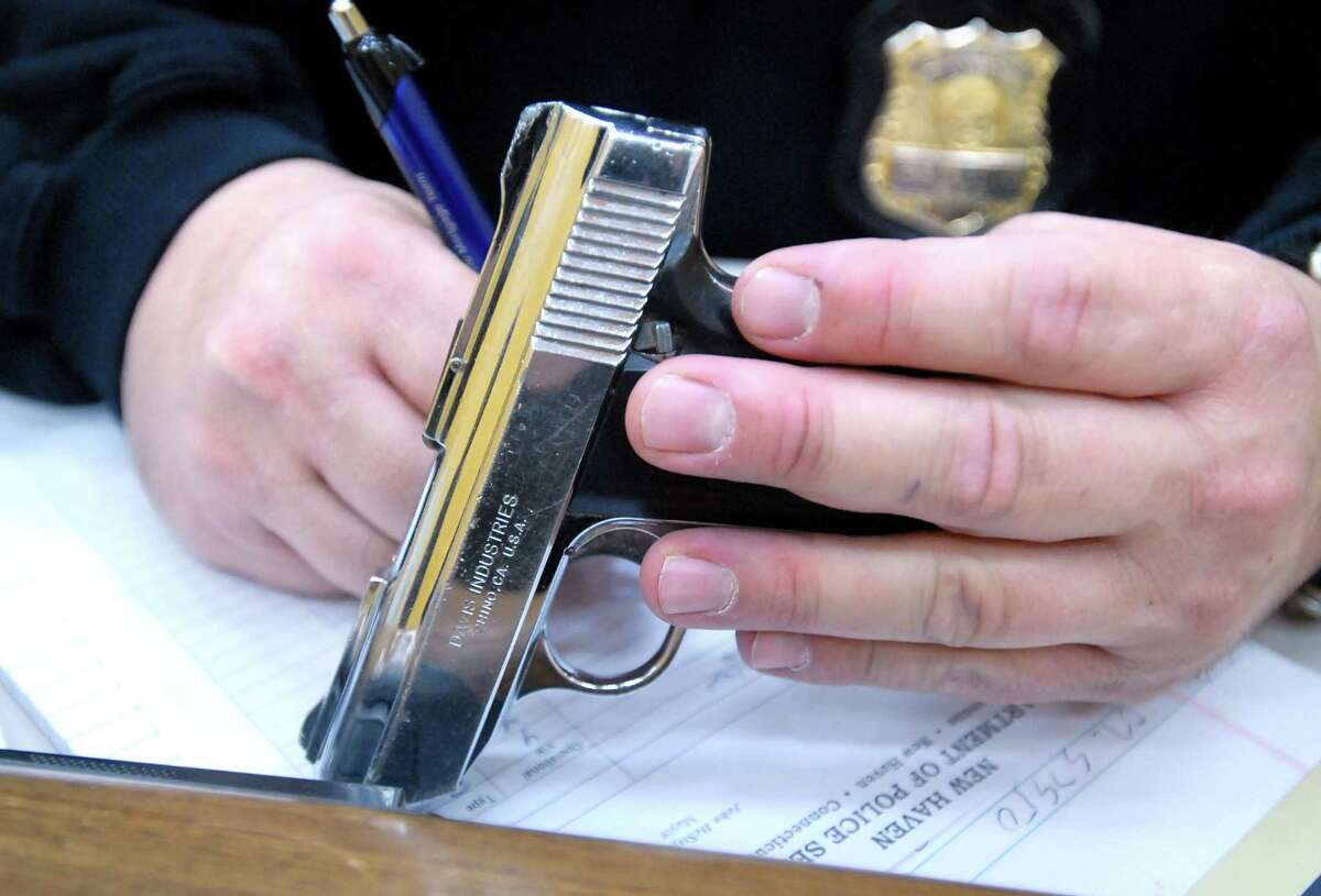 A New Haven Police detective writes down the serial number of a handgun brought into the New Haven Police Department during a gun buyback program in 2007.