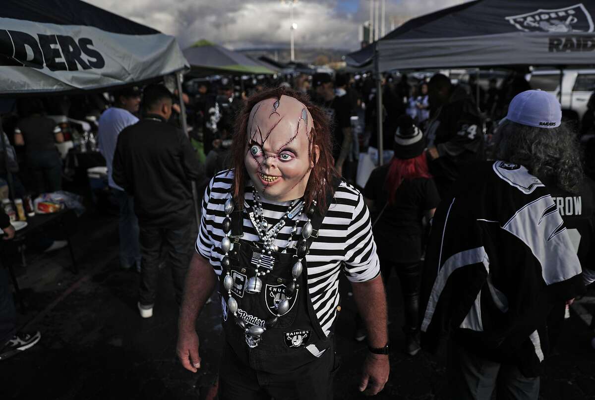 Oakland Raiders fans dressed in costumes arrive at the Oakland